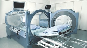 Nurse placed in front of a hyperbaric chamber.